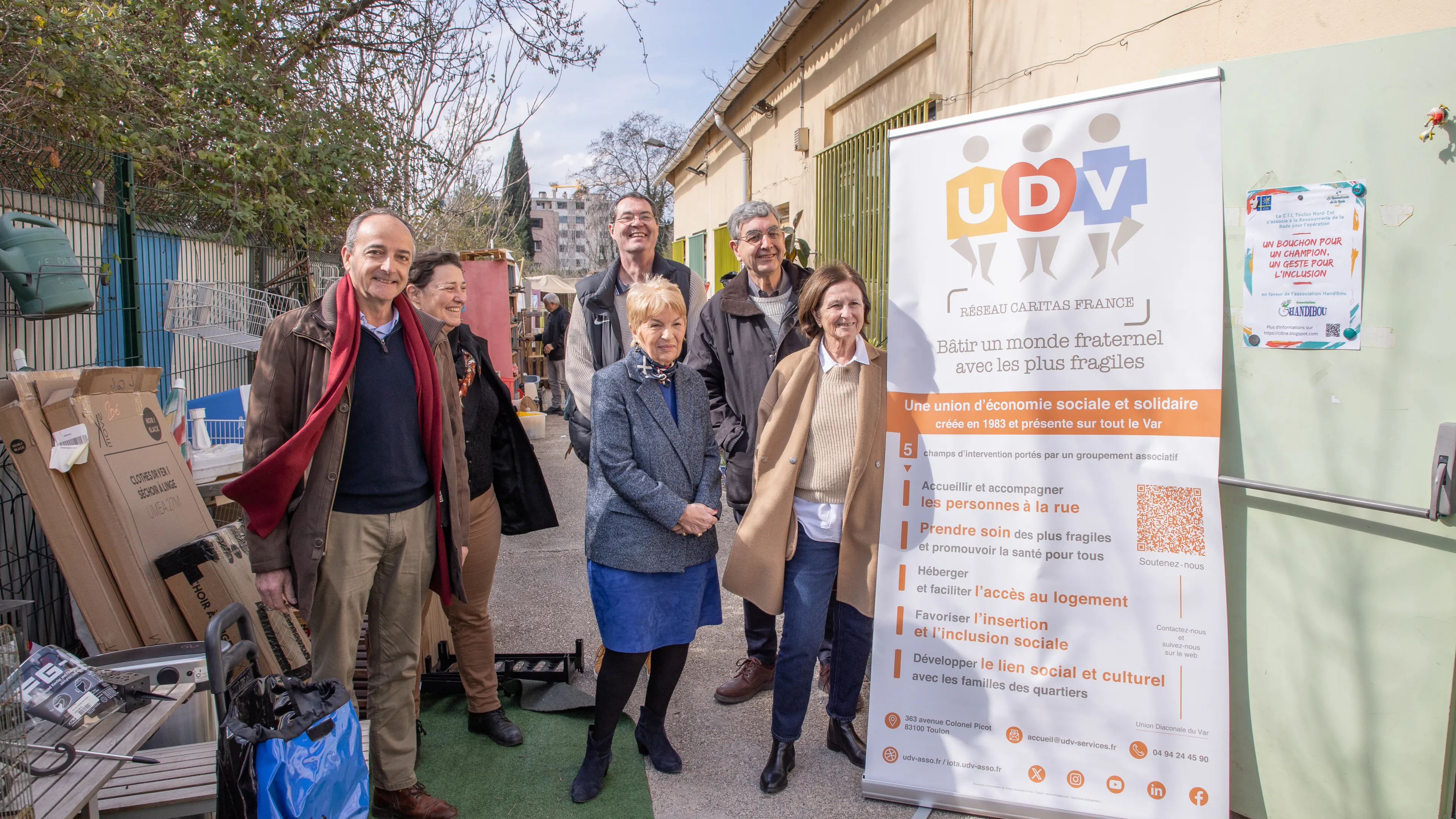 Photo montrant Madame Le Maire accompagnée d'élus municipauxet de bénévoles et usagers de la Ressourcerie du Var. Cette dernière se tient devant une bannière de l'Union Diaconale du Var (UDV).