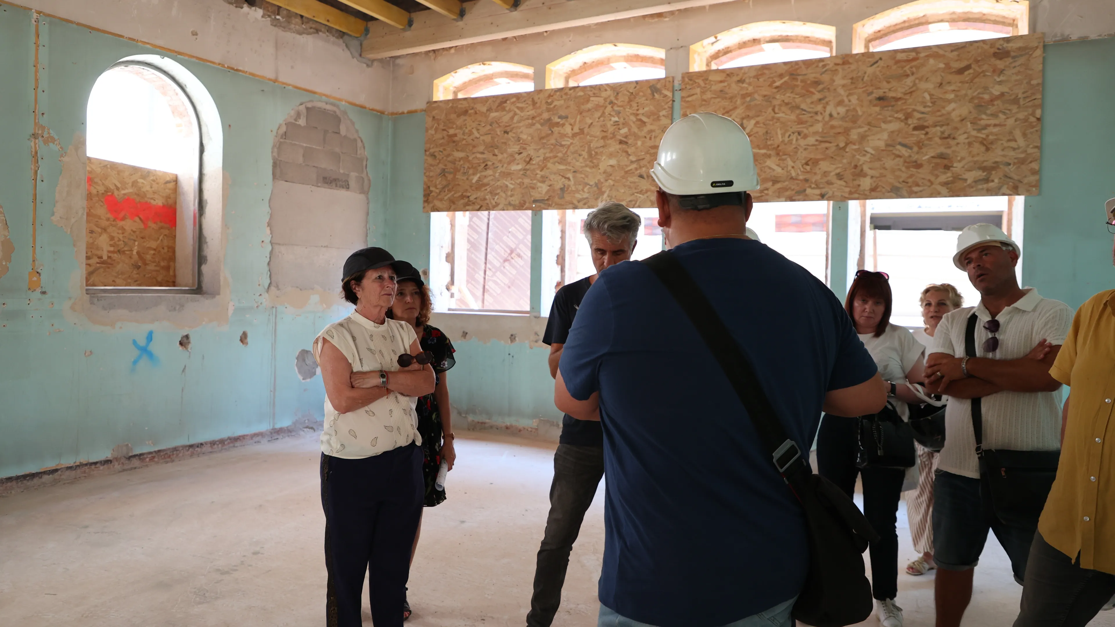 Josée Massi, maire de Toulon, portant un chemisier écru et un pantalon bleu marine écoute les explications d'Eric Boyet, en charge du chantier de la rénovation de l'école élémentaire Saint-Roch.o