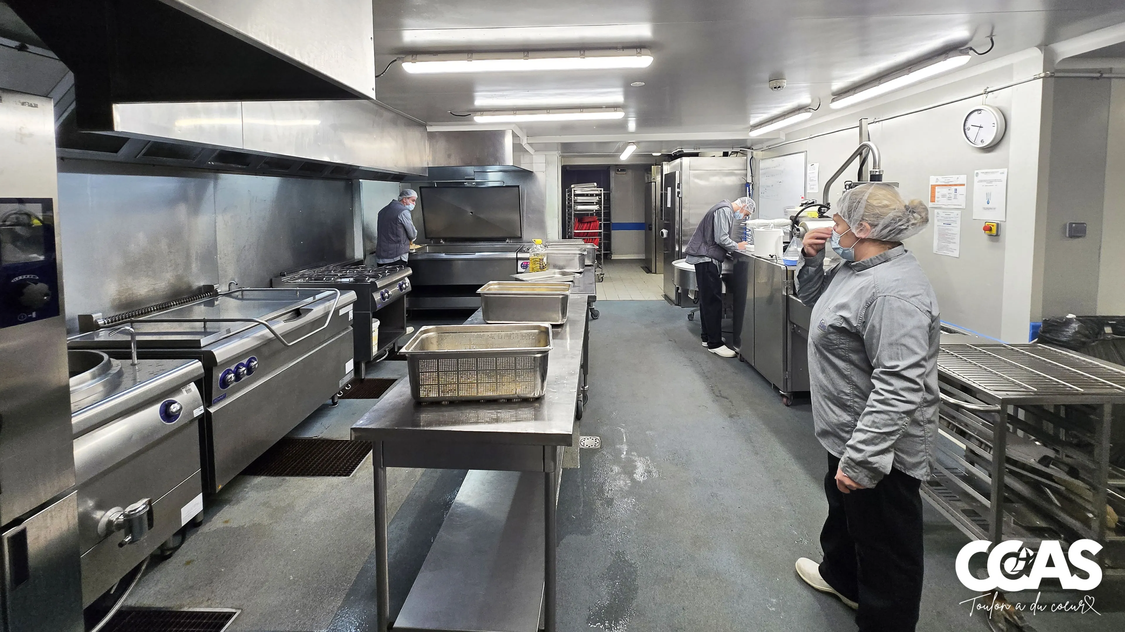 Vue d’ensemble de la zone chaude de l’UPC avec agents en activité autour des équipements de cuisson.