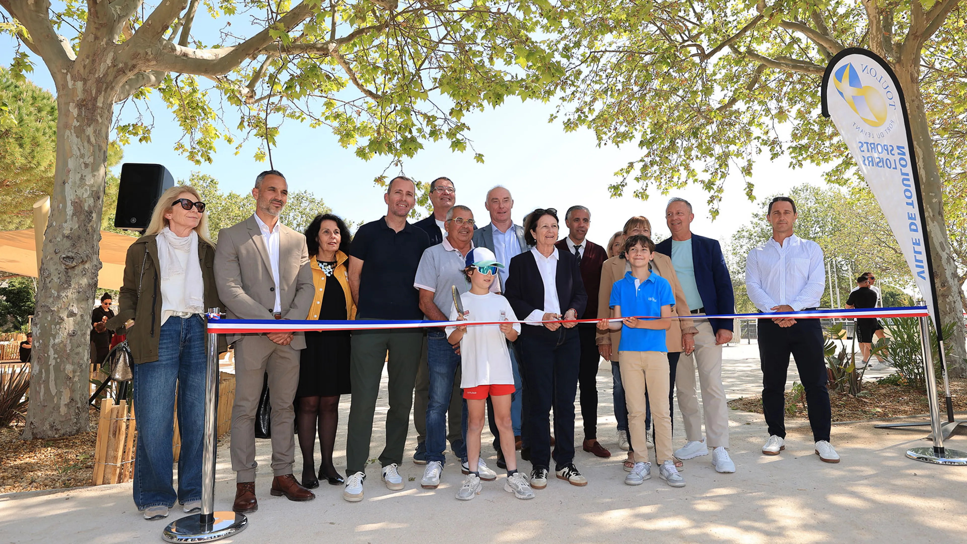 Cette image montre l'inauguration de la plaine des sports. Aucentre, entourée par deux enfants : Josée Massi, maire de Toulon.