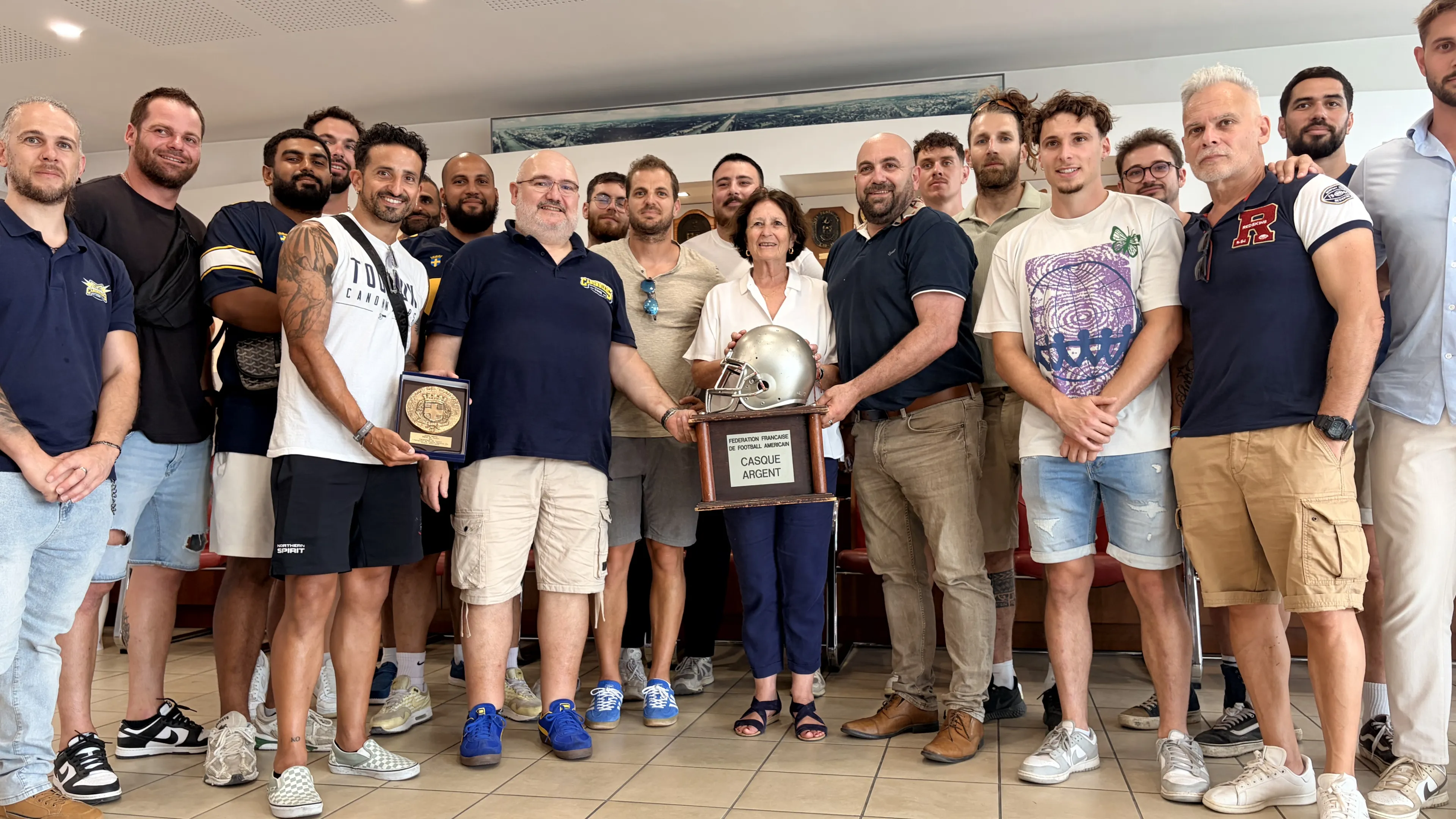 La photo montre Josée Massi entouré des joueurs des Canonniers de Toulon lors de leur réception en Mairie d'Honneur