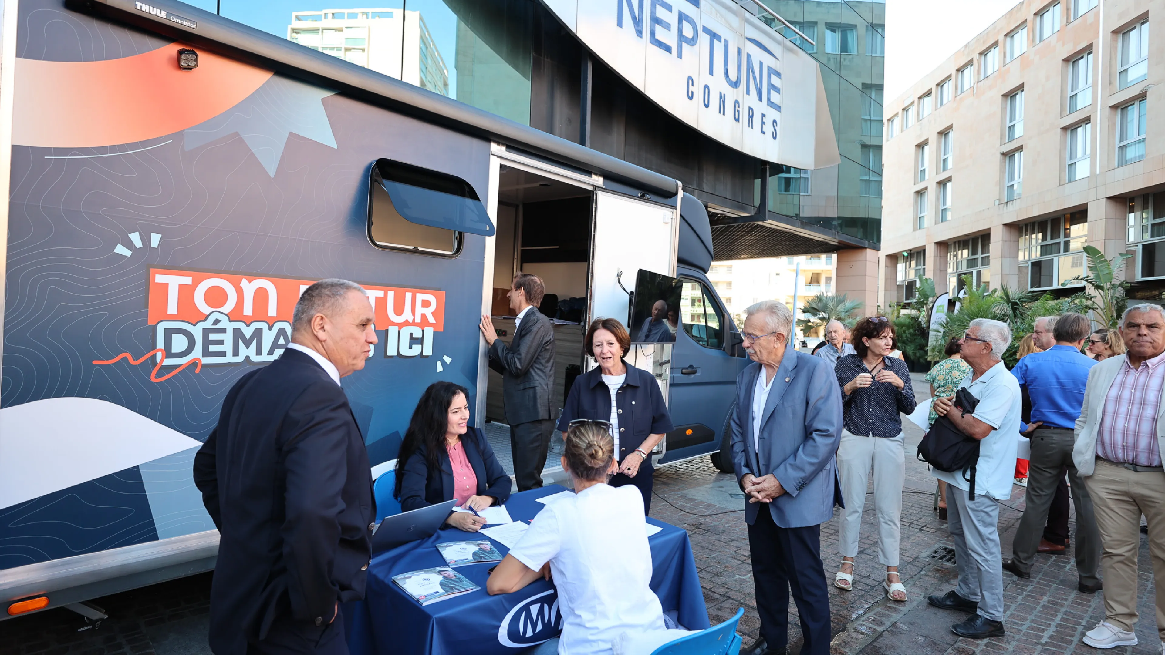 La photo montre Josée Massi, maire de Toulon, à la rencontre des artisans venus se renseigner auprès du bus de l'Artisanat Tour.