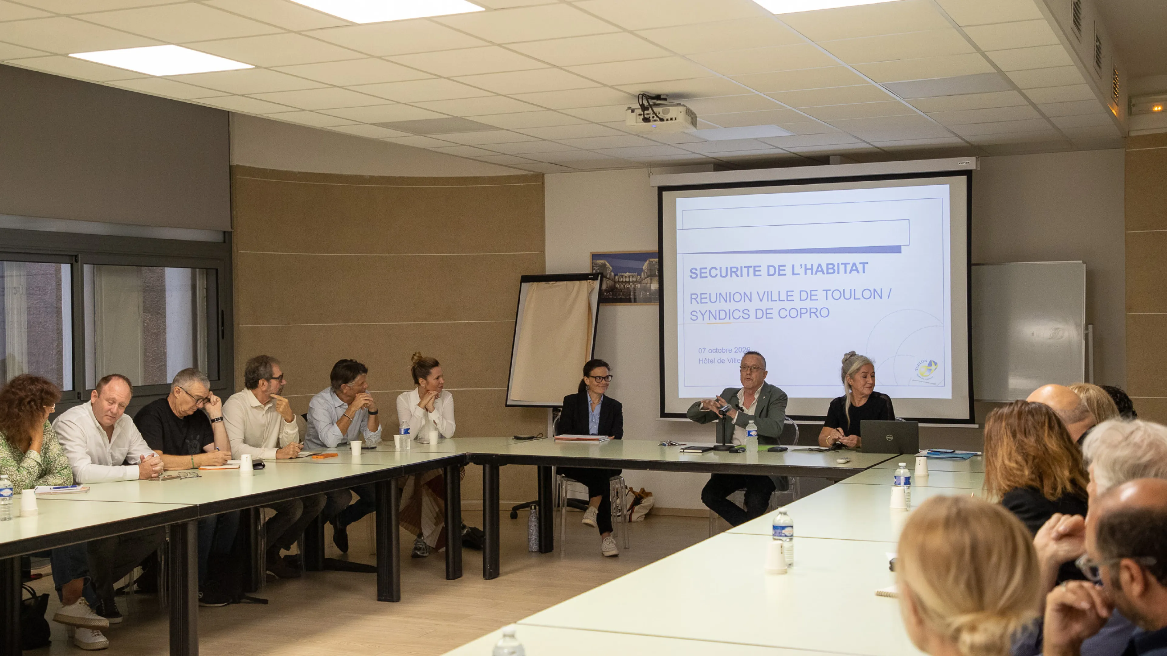 La photo montre la réunion des syndics de copropriété présidée par Serge Lhotellier, adjoint au maire en charge de la sécurité de l'habitat