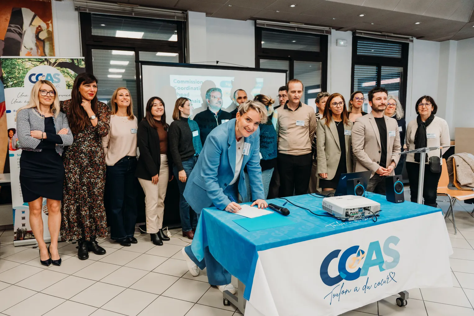 Signature officielle de la charte de la Commission de Coordination des EHPAD du bassin toulonnais par une représentante du CCAS de Toulon, entourée des partenaires réunis.