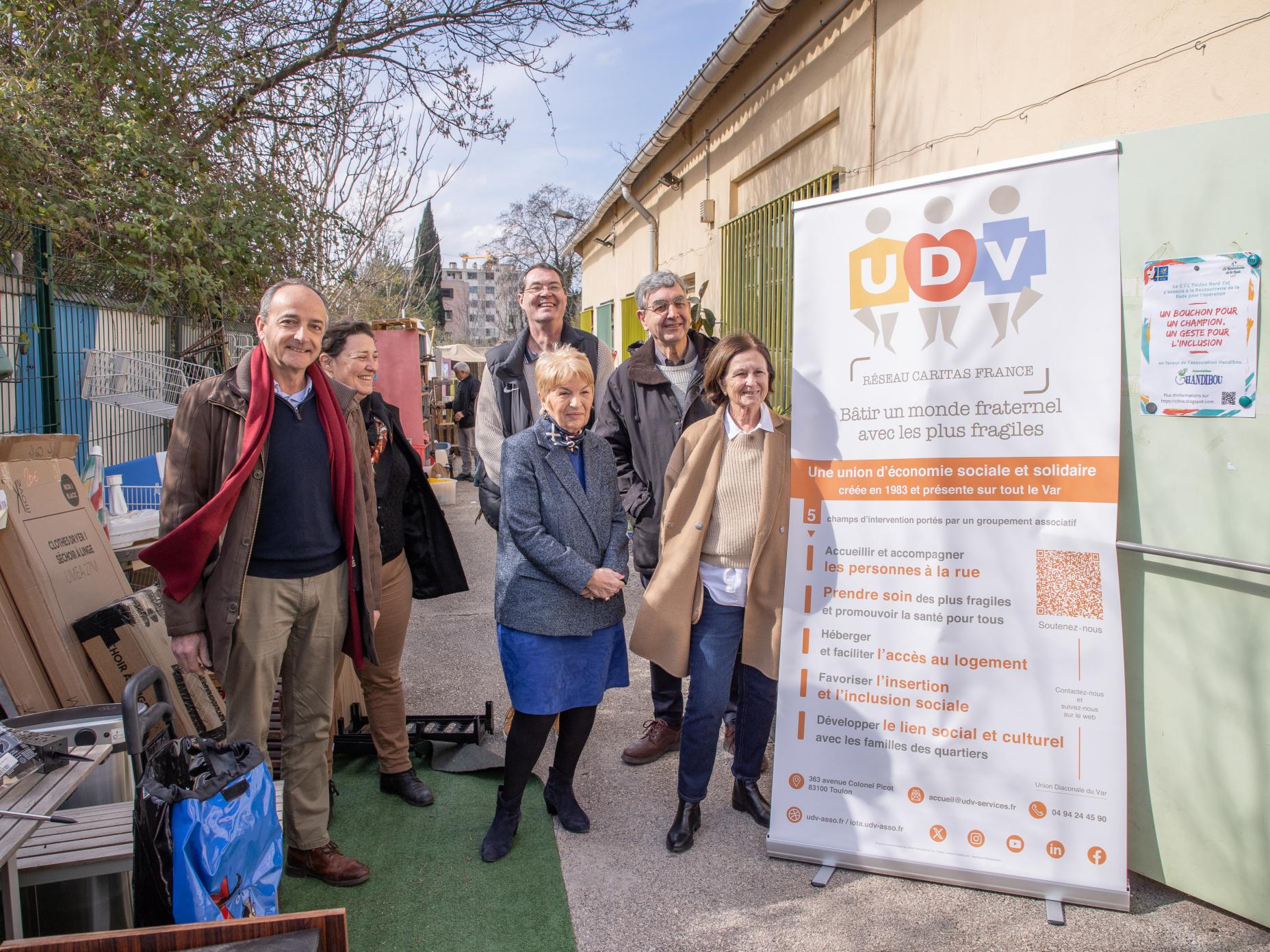 Photo montrant Madame Le Maire accompagnée d'élus municipauxet de bénévoles et usagers de la Ressourcerie du Var. Cette dernière se tient devant une bannière de l'Union Diaconale du Var (UDV).