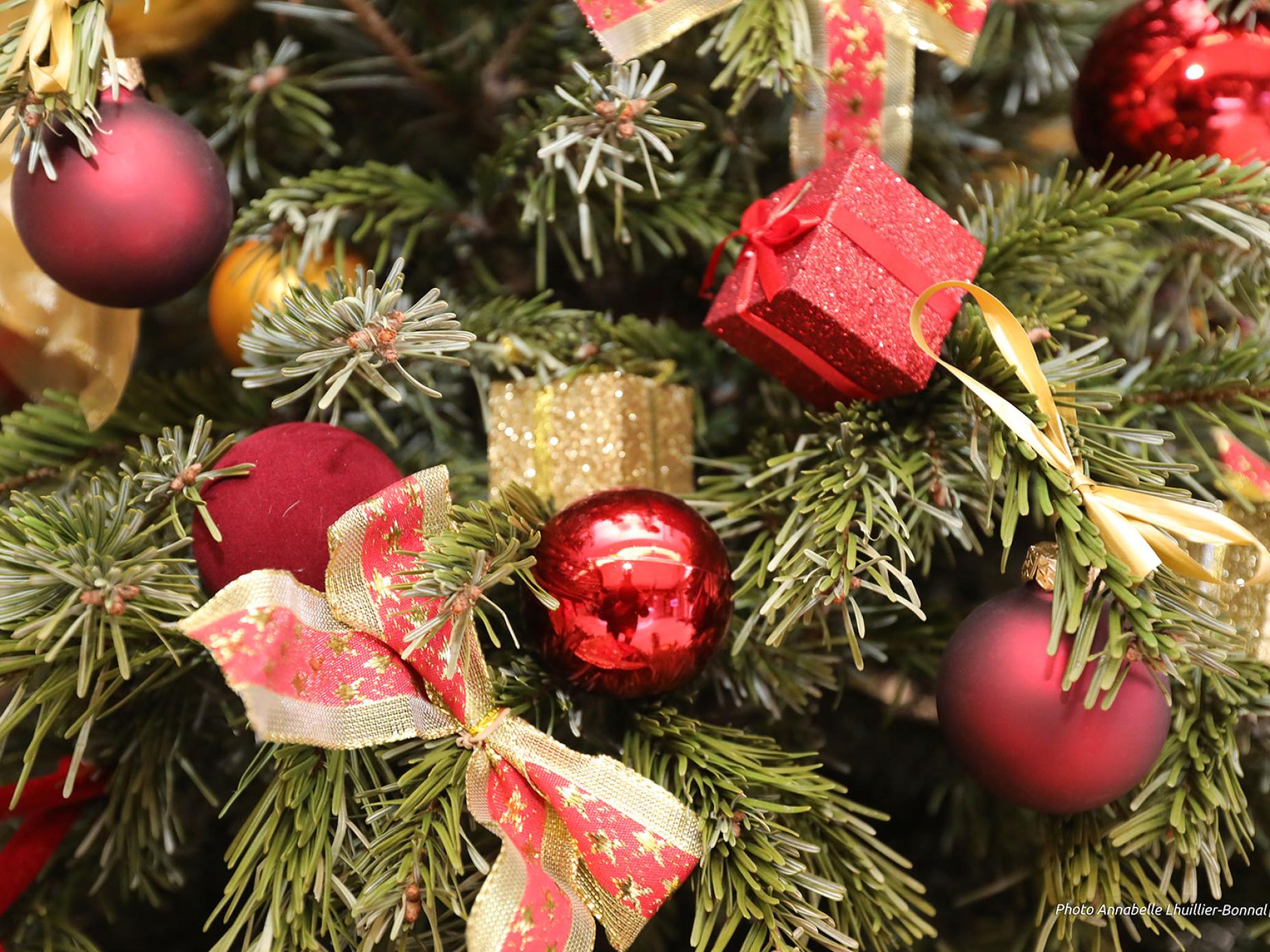 Il s'agit d'un détail d'un sapin de Noël décorés par des boules, des cadeaux et des noeuds rouge et or.