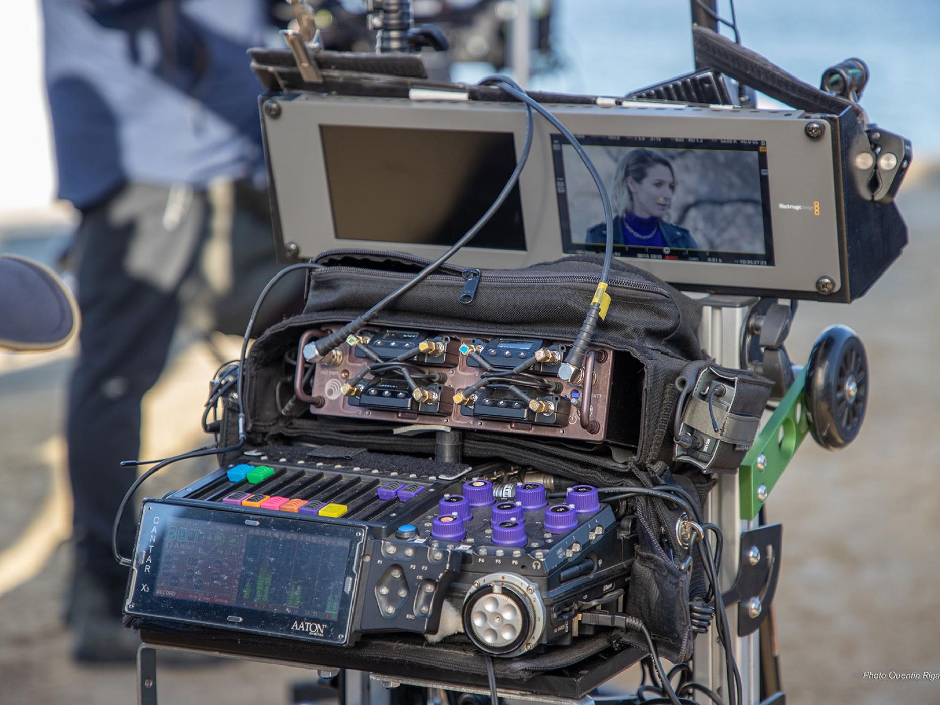 la photo montre les coulisses techniques d’un tournage, avec un focus sur le travail du preneur de son et la synchronisation image/son.