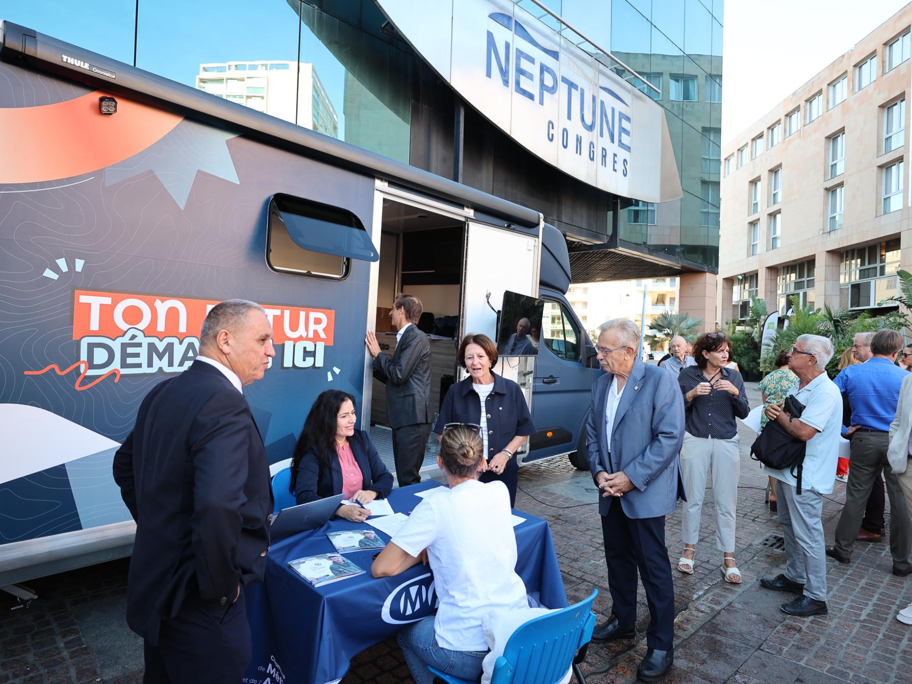La photo montre Josée Massi, maire de Toulon, à la rencontre des artisans venus se renseigner auprès du bus de l'Artisanat Tour.