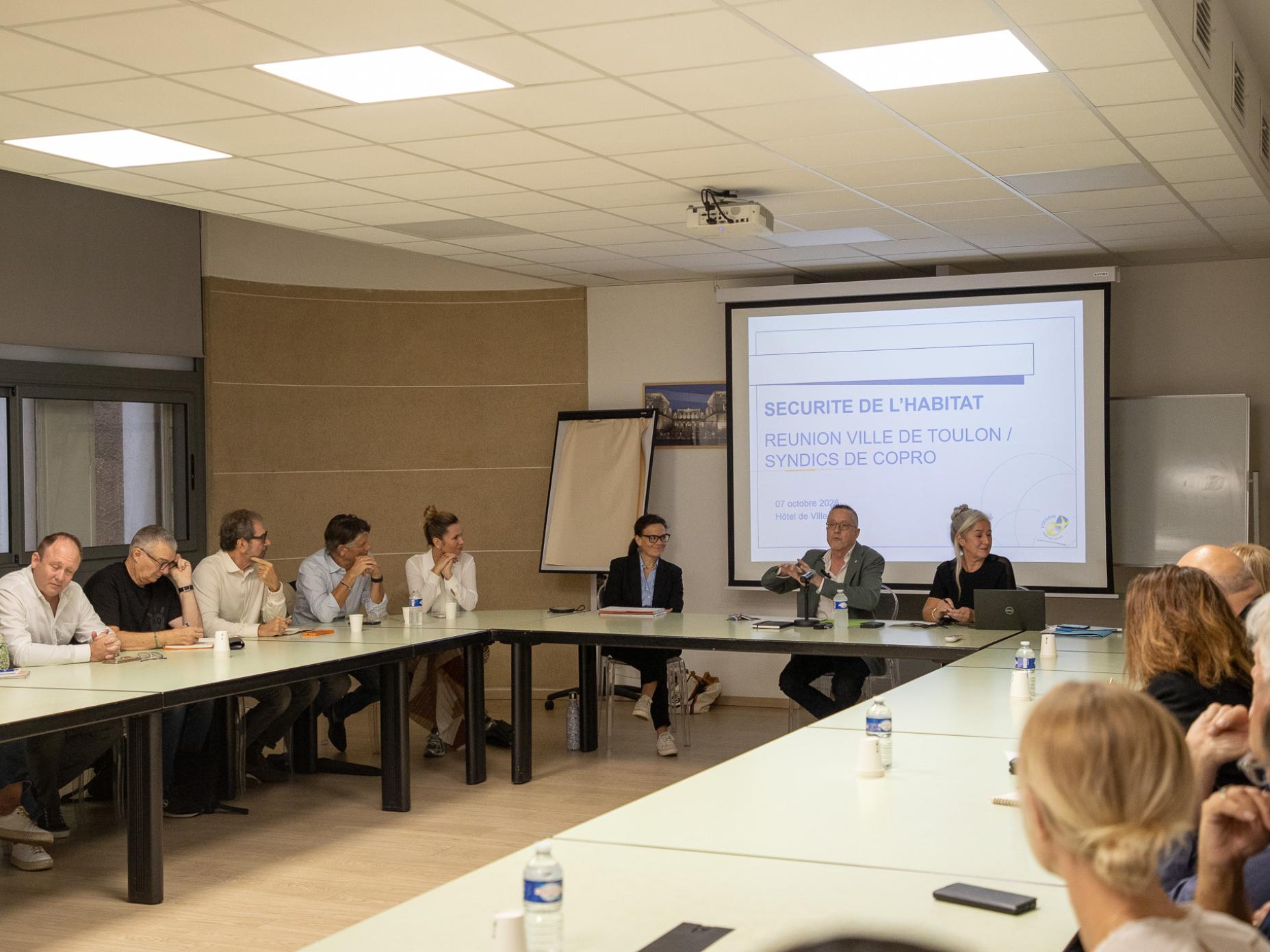 La photo montre la réunion des syndics de copropriété présidée par Serge Lhotellier, adjoint au maire en charge de la sécurité de l'habitat
