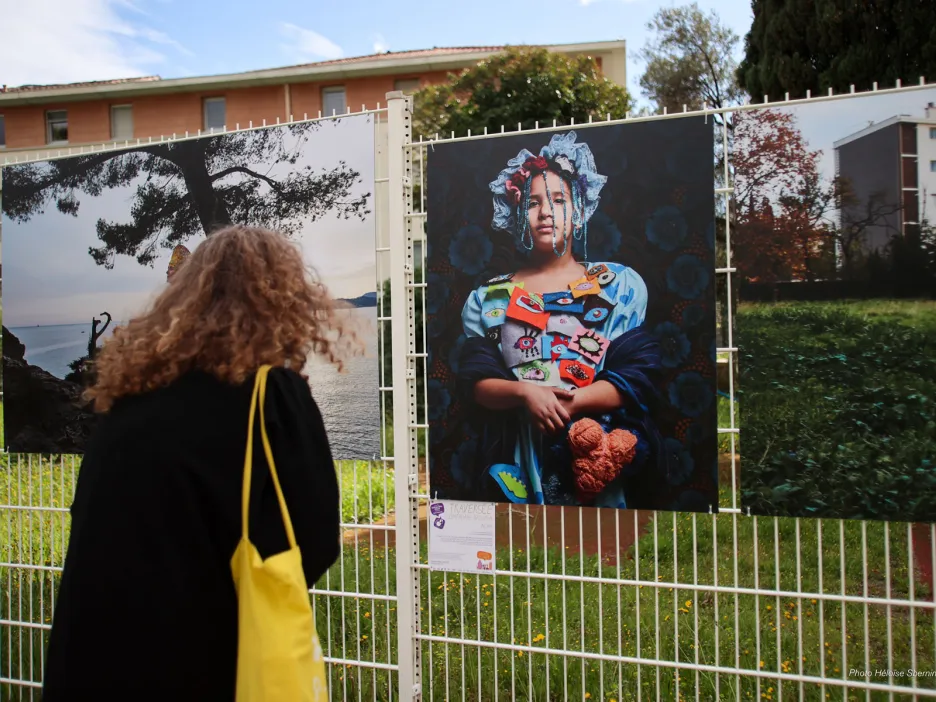 Photo d'une femme de dos contemplant une illustration de l'exposition