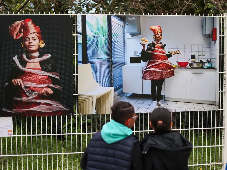 Photo montrant deux enfants de dos échangeant autour d'une illustration de l'exposition.
