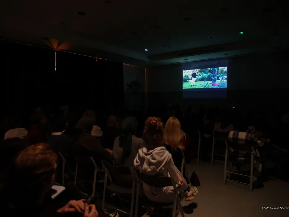 Photo dans une pièce sombre dans laquelle est projetée le documentaire