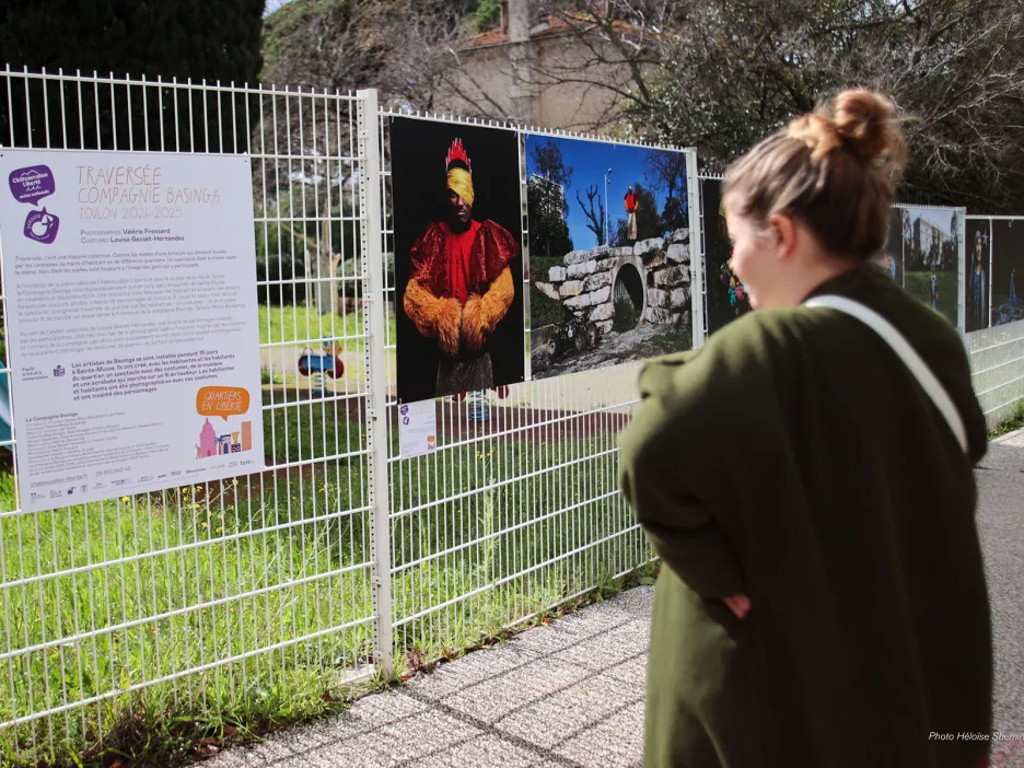Photo d'une jeune femme de dos observant l'exposition photo