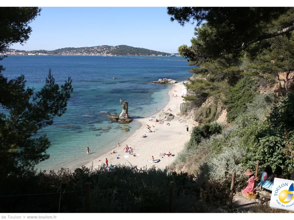 Photographie de la Plage de la Mitre sur laquelle on peut apercevoir au loin plusieurs personnes allongés sur le sable, et quelques-uns dans l'eau