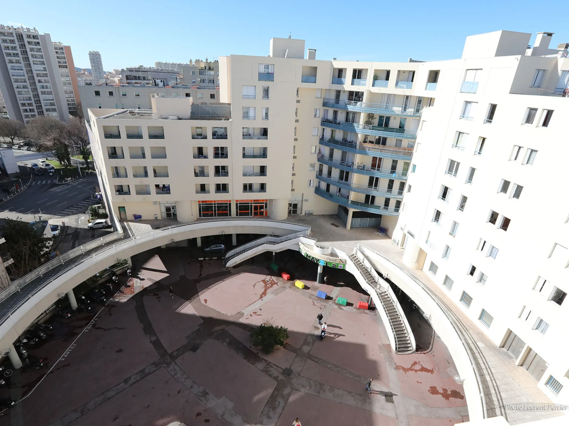 Place donnant sur l'entré du centre commercial Mayol, ainsi que des escaliers donnant sur une passerelle qui entoure la place
